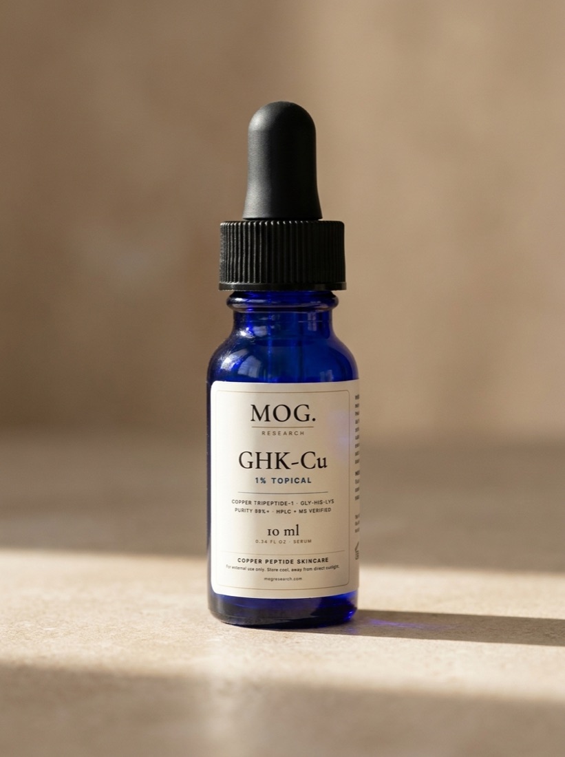MOG Glow Peptide Serum in a cobalt glass dropper bottle